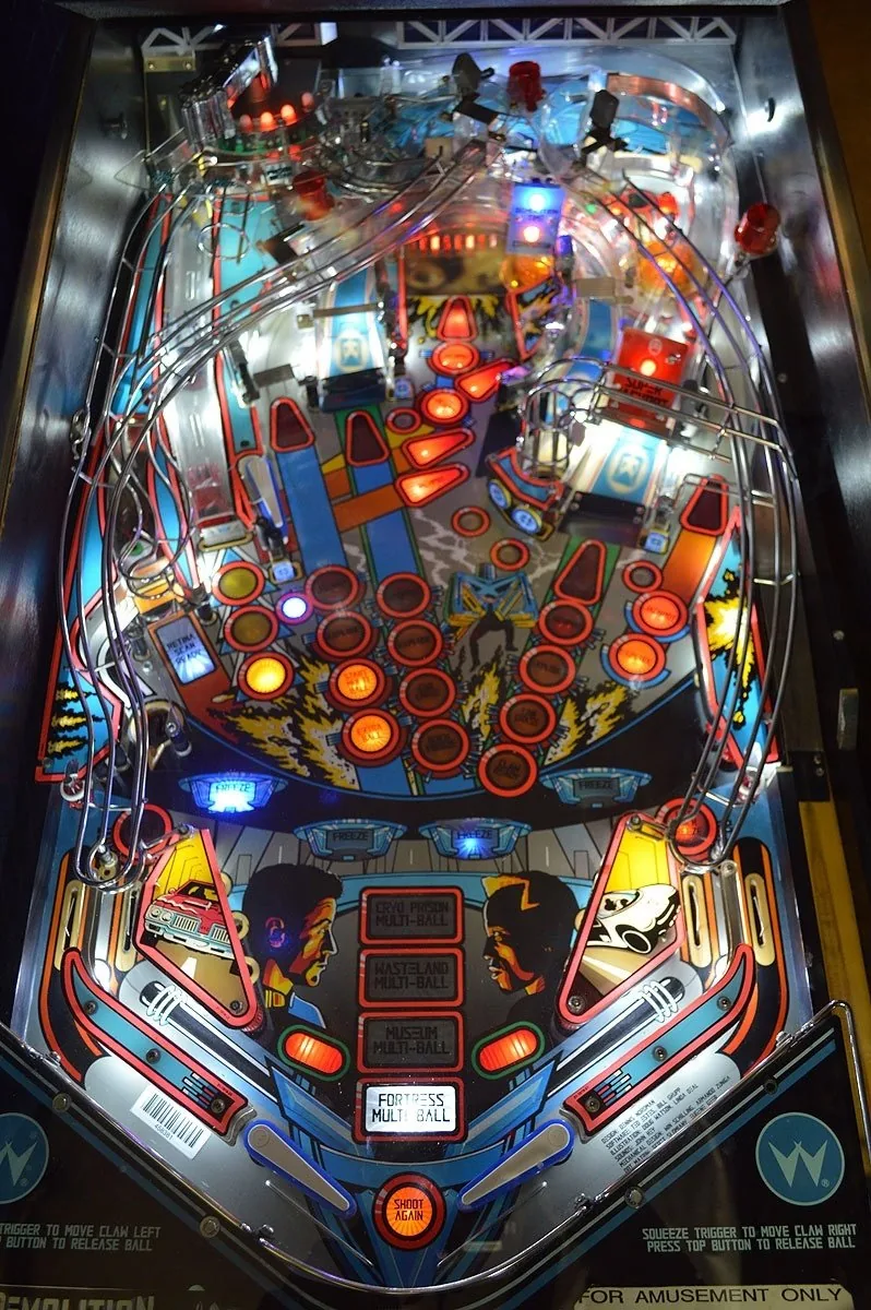 Bovenaanzicht van het Williams Demolition Man speelveld met de grijpklauw, de multiball-doelen en de Freeze-targets