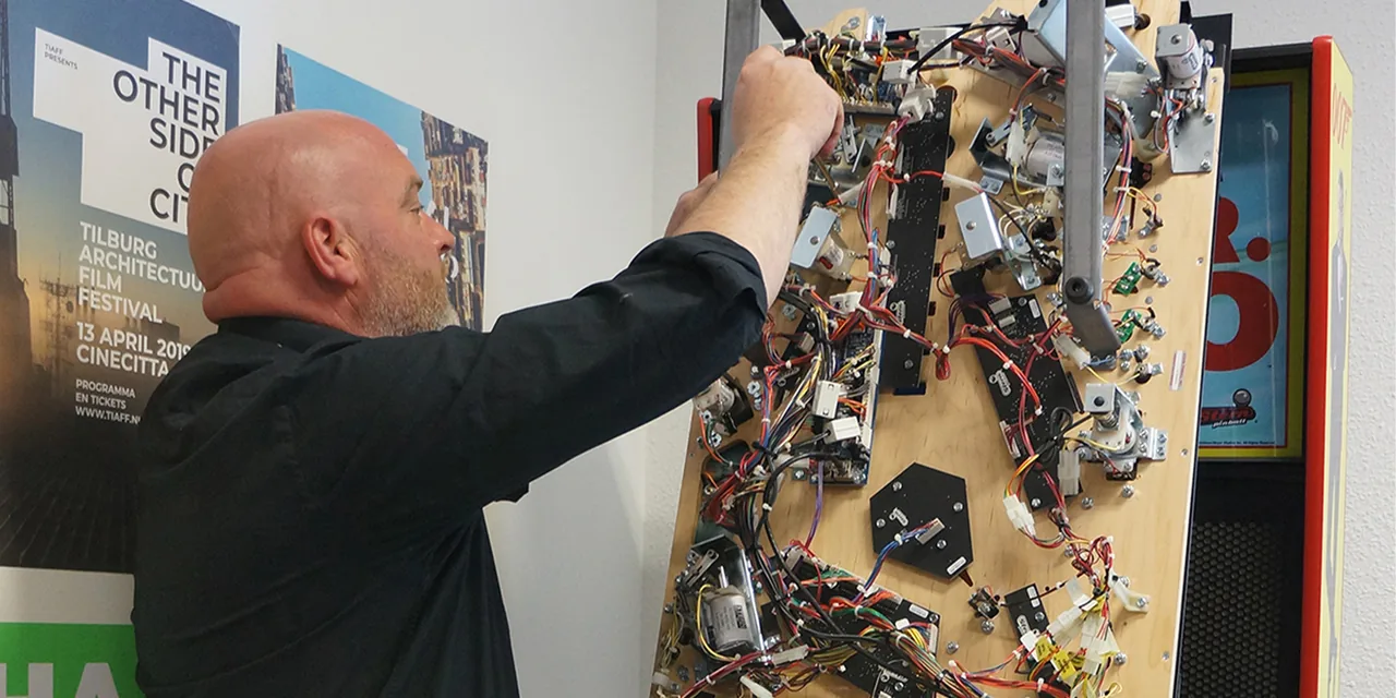 Servicetechnicus werkt aan het speelveld van een gehuurde flipperkast