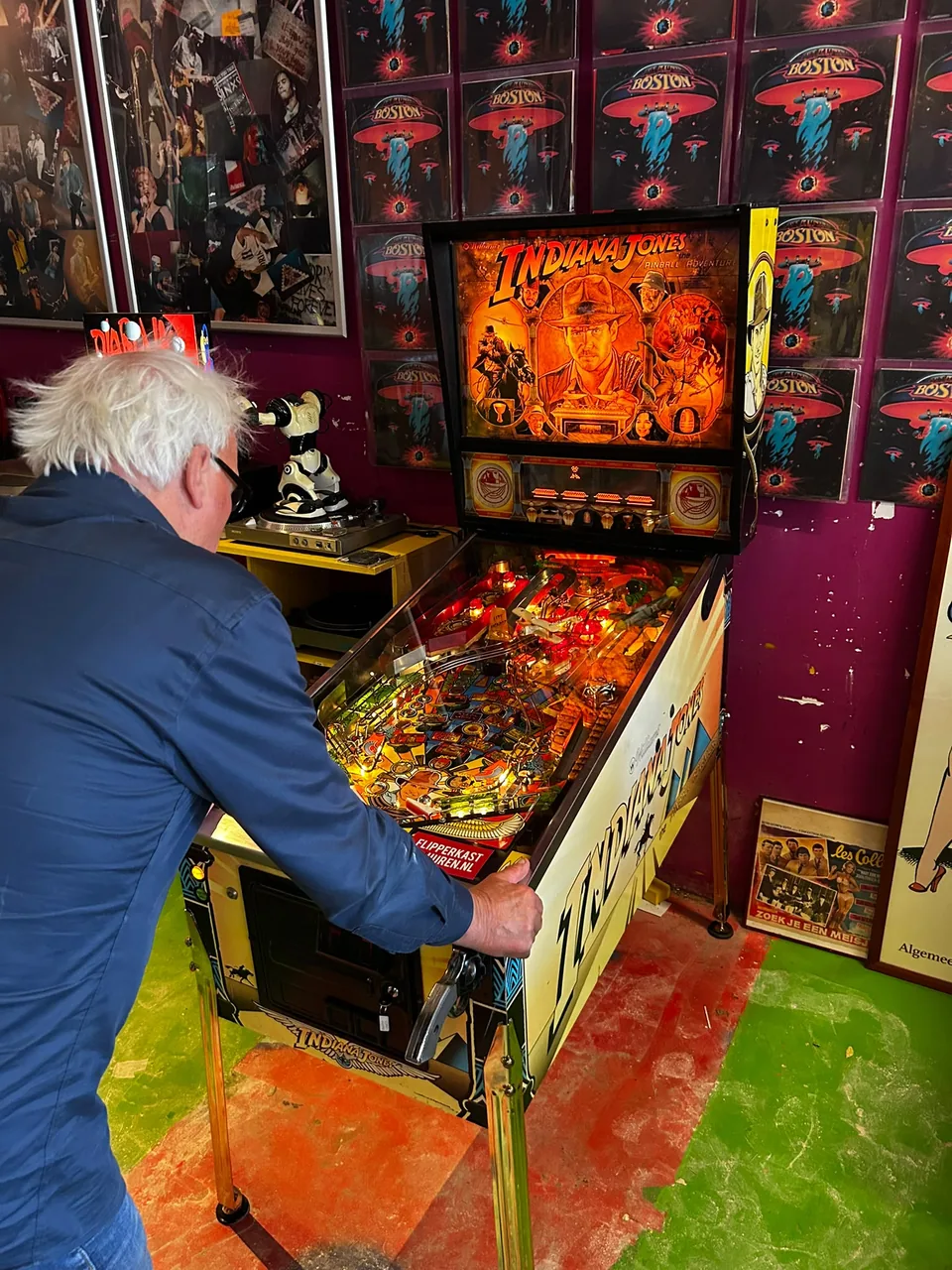 Rolf van GoodTimes speelt op de Indiana Jones flipperkast in zijn muziekwinkel in Alkmaar